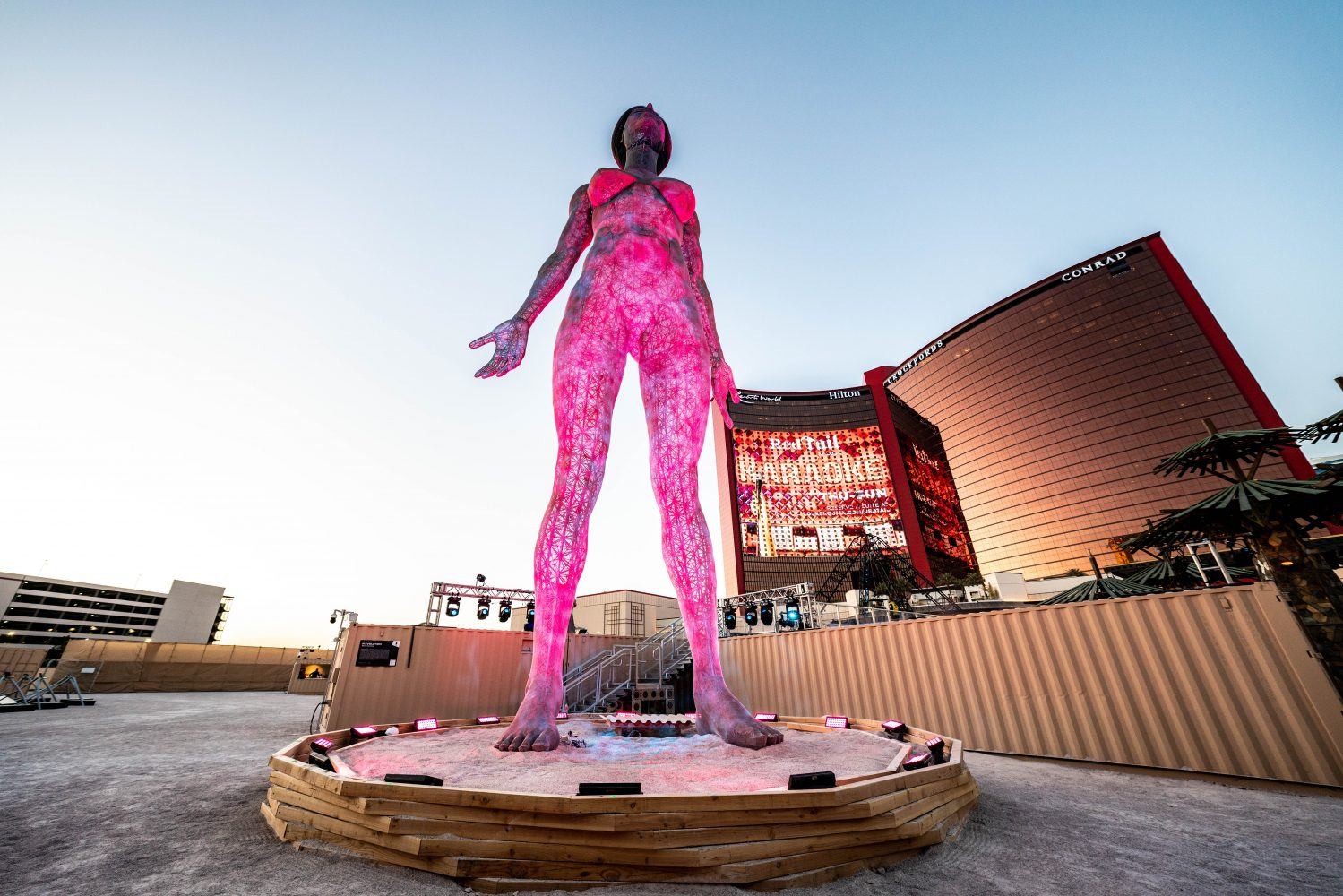 large metal women's shape illuminated in front of a modernist building in las vegas