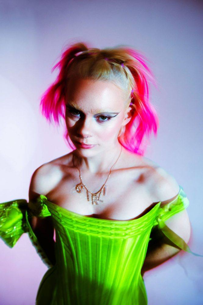 portrait of a girl with pink hair in a lime green corset and girli necklace