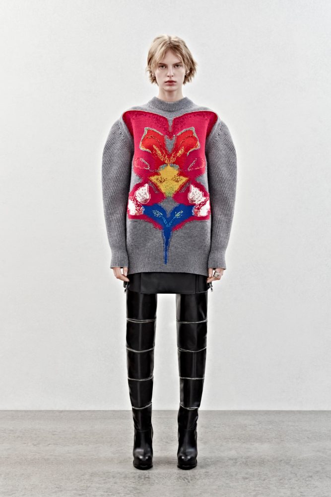 An oversized jumper in grey wool with a solarized mirrored orchid intarsia and a biker skirt in black leather.