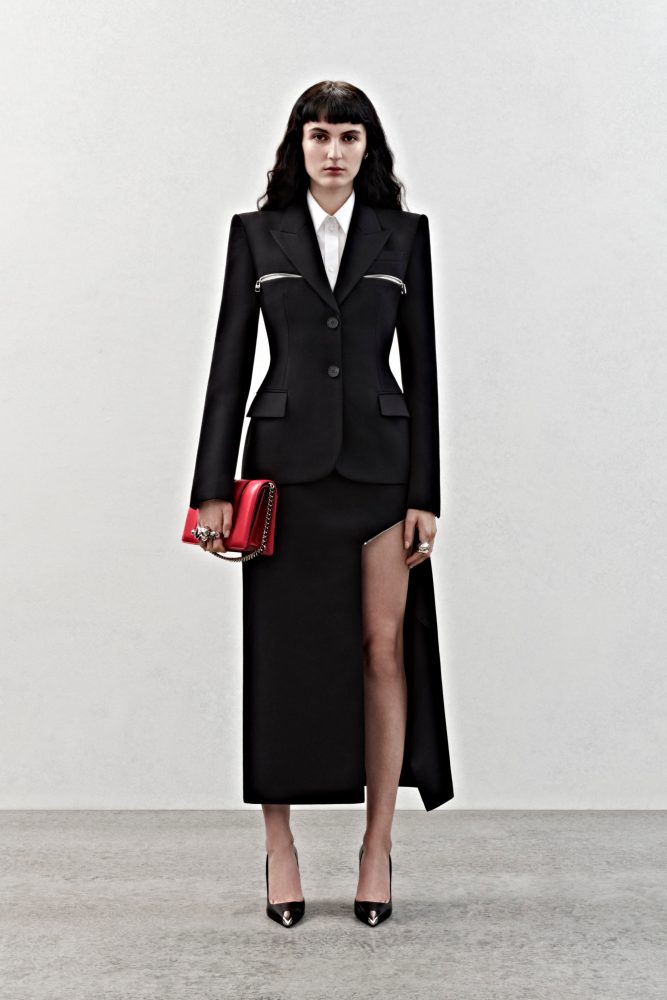 A single-breasted tailored jacket and slashed skirt in black grain de poudre with silver metal zip detailing and a shirt in white cotton poplin.