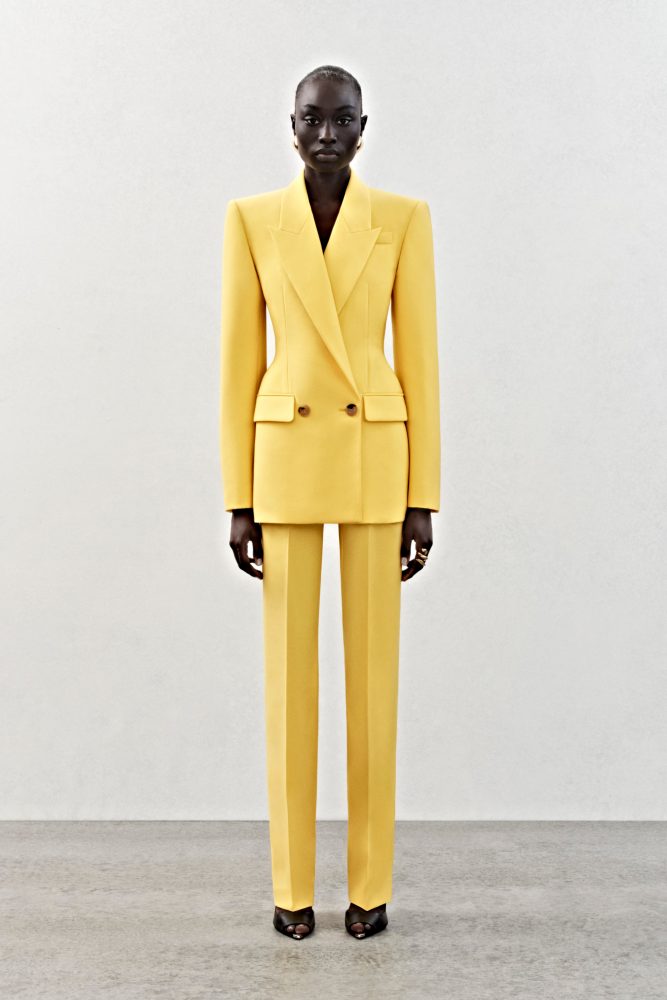 A double-breasted jacket and high-waisted trousers in bright yellow wool.
