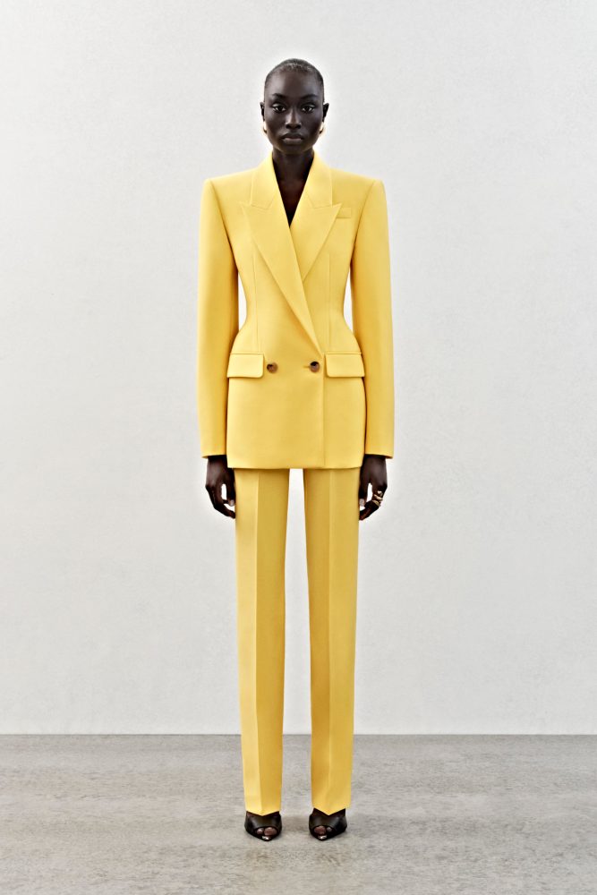 A double-breasted jacket and high-waisted trousers in bright yellow wool.
