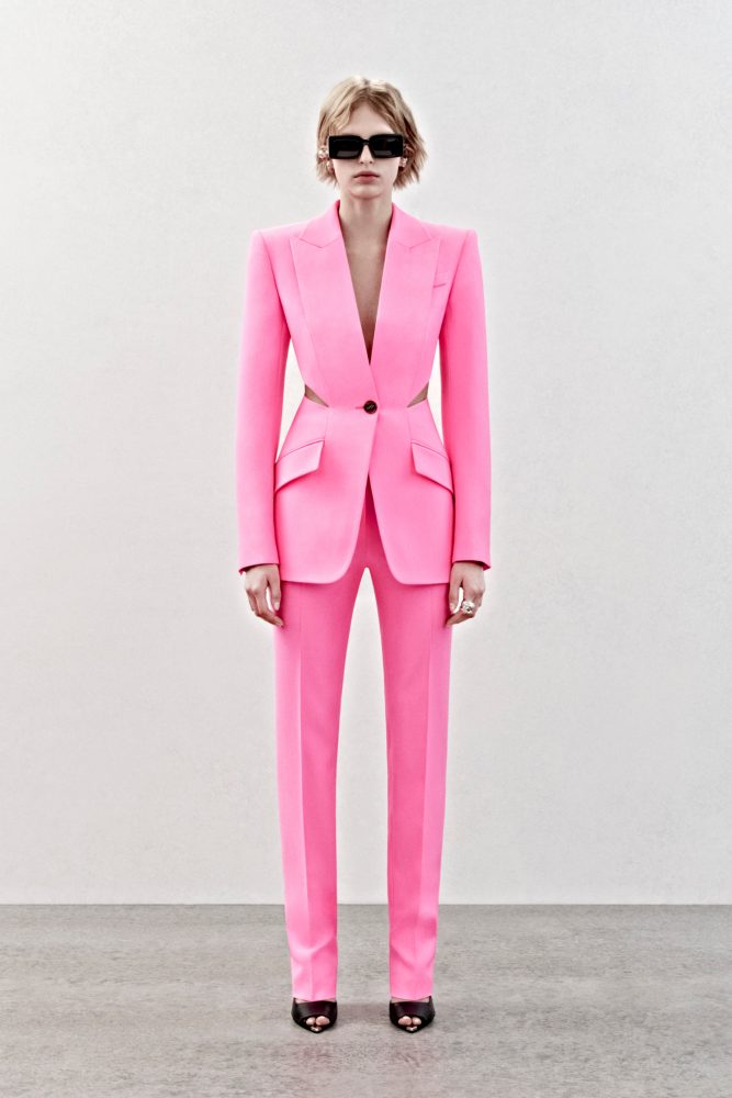 A single-breasted tailored jacket with a cutaway back and high-waisted trousers in pink wool.