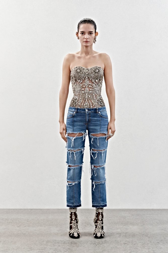 A bustier in tulle with crystal embroidery and slashed bumster trousers in blue denim.