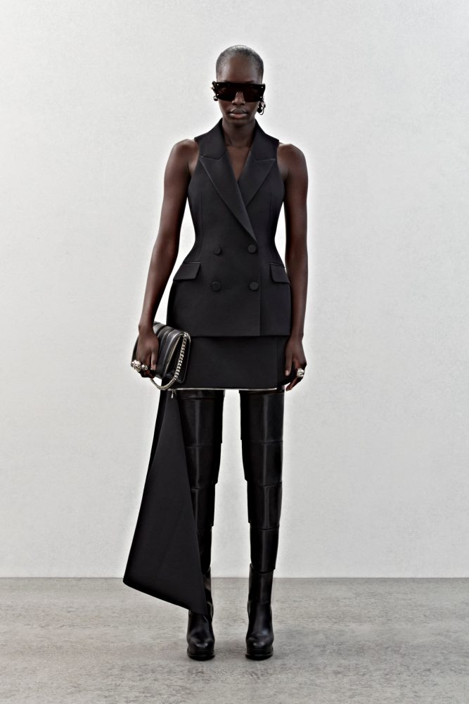 A sleeveless double-breasted tailored jacket and a slashed skirt in black grain de poudre.