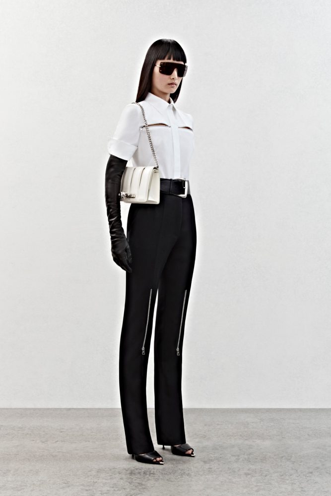 A shirt in white cotton poplin with silver metal zip detailing and high-waisted trousers in black grain de poudre with silver metal zip detailing.