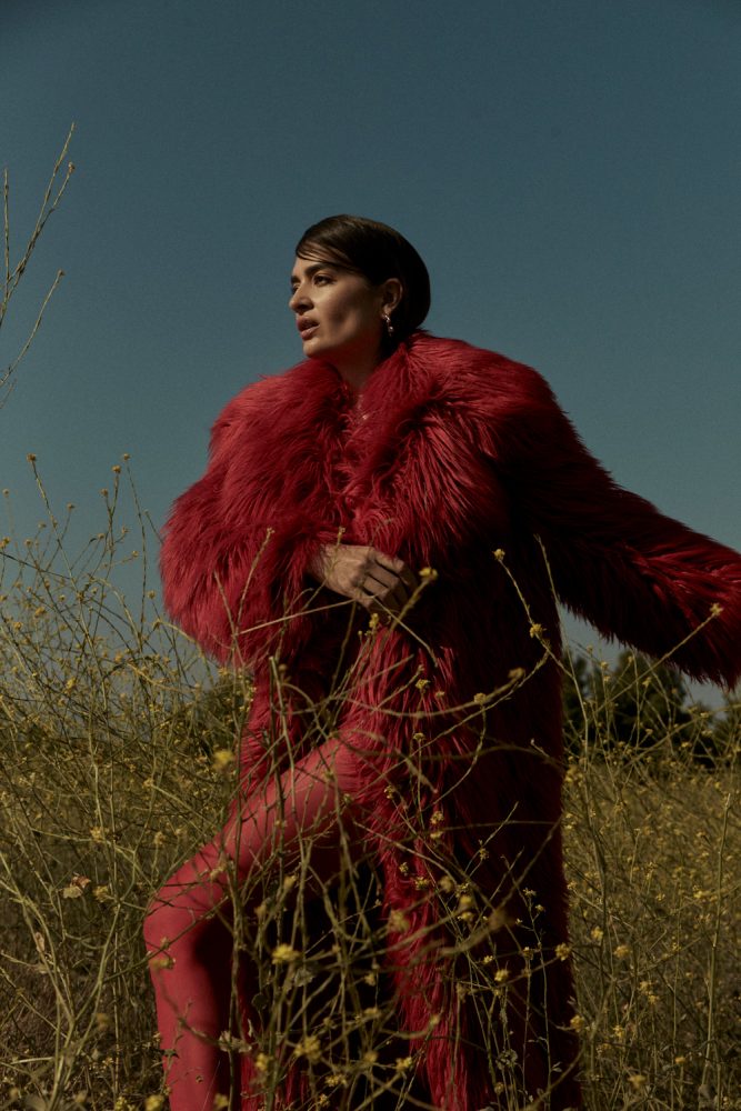 Natalia Bonifacci wears coat by MSGM, earrings by Hannah Jewett, necklace by Hernán Herdez, and stylist's shoes and tights. image 1 photographed by Mathilde Bresson