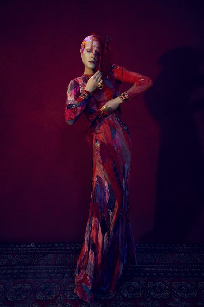 Jordan Roth wears Olivier Theyskens dress, Grace Elizabeth feathers, Gianvito Rossi shoes, Loulou de la Falaise bracelets, and New York Vintage rings photo 2