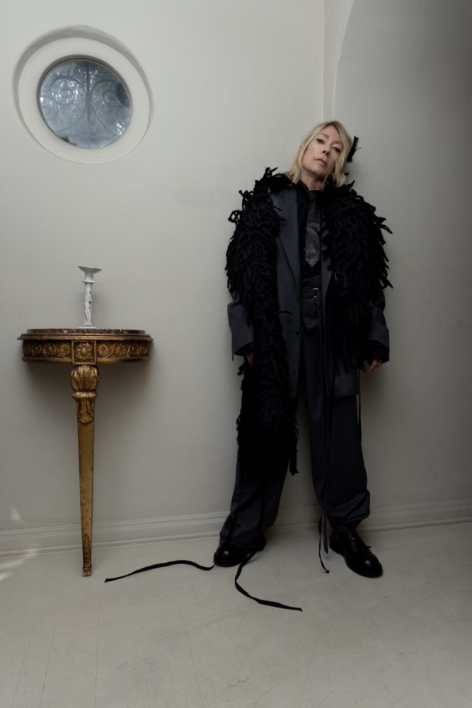 Kim Gordon wears ANN DEMEULEMEESTER coat, suit, shirt, tie, and shoes. Photographed by Jason Renaud. Styled by BJ Panda Bear and Paul Rizzo. Hair by Paul Rizzo using Bumble and Bumble Makeup by Nicole Servin Joshua Nixon