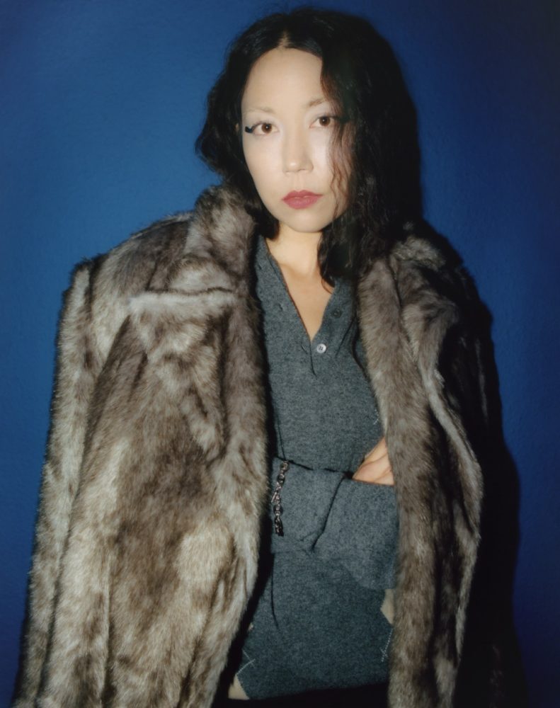 Sasami wears AKANVAS coat and MIU MIU sweater available at FWRD. Written and Produced by BJ Panda Bear. Photographed by Andrew Friendly. Styled by Britton Litow. Hair: Paul Rizzo using Bumble and Bumble. Makeup: Nichole Servin using Westman Atelier and Rare Beauty. Stylist Assistant: Maddie Collins.
