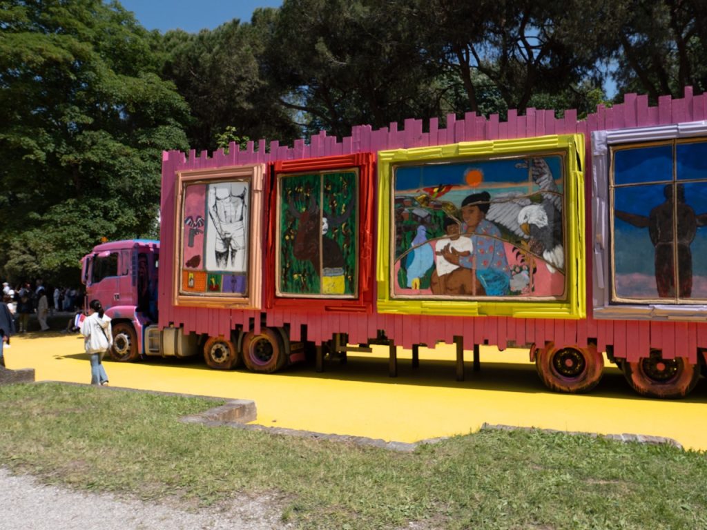 VENICE ART BIENNALE DIARY with Artist Jenny Sharaf Labor Day Parade ’91 (2026), a large-scale installation by Alvaro Barrington presented in the Giardini during the 61st Venice Biennale. The vividly painted freight truck — driven from London to Venice by the artist himself — combines autobiographical imagery, references to Caribbean and European histories, and art historical motifs into a moving monument to migration, labor, and cultural memory.