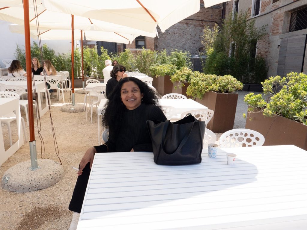 VENICE ART BIENNALE DIARY with Artist Jenny Sharaf Exhibiting artist, Rajni Pereira, “off-duty” at the Arsenale. She was presenting a wonderful sculpture, with her collaborator Marigold Santos. The installation was composed of clay, flowers, pearls, moss and hair.