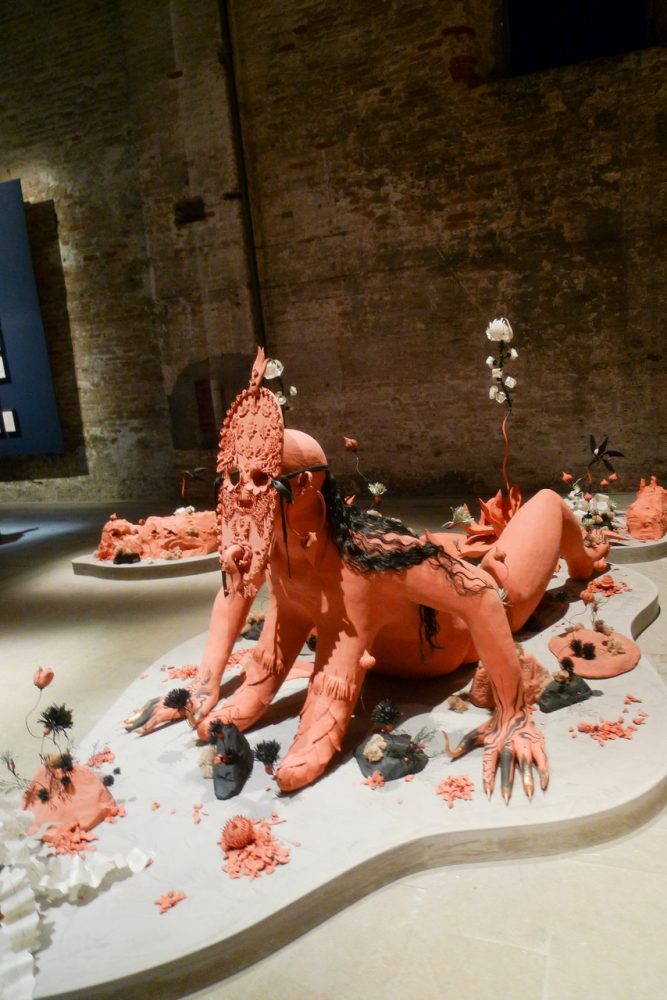 VENICE ART BIENNALE DIARY with Artist Jenny Sharaf Exhibiting artist, Rajni Pereira, “off-duty” at the Arsenale. She was presenting a wonderful sculpture, with her collaborator Marigold Santos. The installation was composed of clay, flowers, pearls, moss and hair.